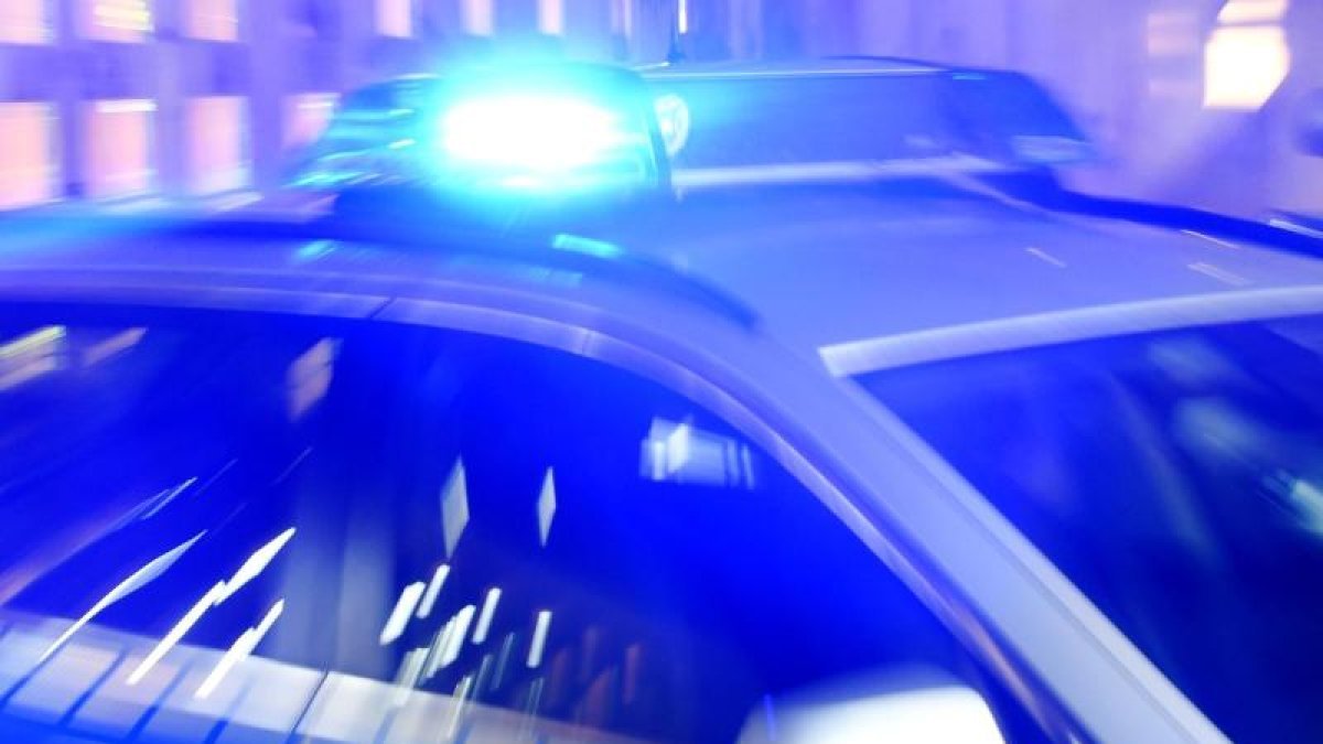 Ein-Streifenwagen-der-Polizei-steht-mit-eingeschaltetem-Blaulicht-auf-der-Strasse